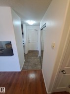Entryway featuring a paneled door, ceiling-mounted light fixture, mirrored closet doors, and tile flooring - 