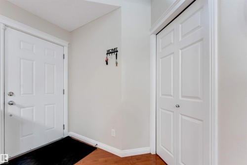 Entryway featuring a paneled door, wood-finish flooring, and white trim - 3012 25 Ave Avenue, Edmonton, AB 