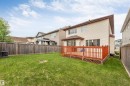 Spacious rear yard with a wooden privacy fence, expansive green lawn, and a multi-level wooden deck featuring a lattice skirt - 3012 25 Ave Avenue, Edmonton, AB 