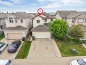 Two-story property featuring a double-car garage, light-colored siding, and a gabled roofline - 3012 25 Ave Avenue, Edmonton, AB 