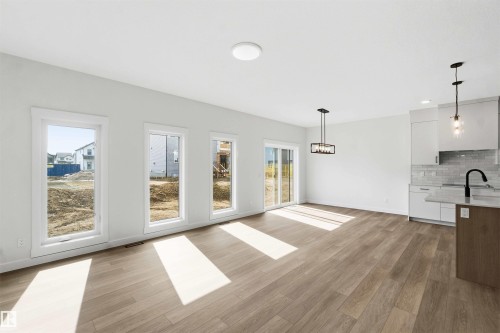 Open-concept living space featuring wood-finish flooring, white walls, and recessed lighting - 1085 Cristall Crescent, Edmonton, AB 