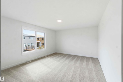 Bright interior space featuring a large window, recessed lighting, and neutral-toned wall-to-wall carpeting - 1085 Cristall Crescent, Edmonton, AB 