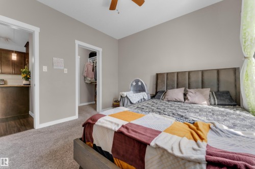 Spacious bedroom with neutral wall tones and plush carpeting - 115 812 Welsh Drive Sw, Edmonton, AB 