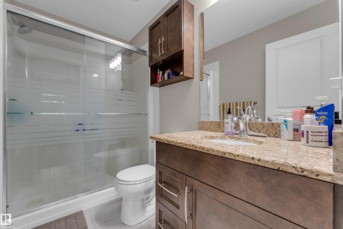 Bathroom with a dark wood-finish vanity, light-toned countertop, and undermount sink - 115 812 Welsh Drive Sw, Edmonton, AB 