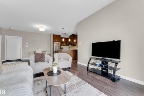 Living area featuring dark wood-finish flooring, light-toned walls, and recessed lighting - 115 812 Welsh Drive Sw, Edmonton, AB 