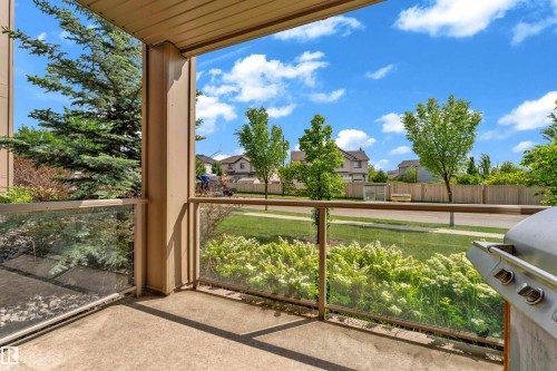 Outdoor patio featuring a concrete floor, glass panel railing, and beige support columns - 115 812 Welsh Drive Sw, Edmonton, AB 