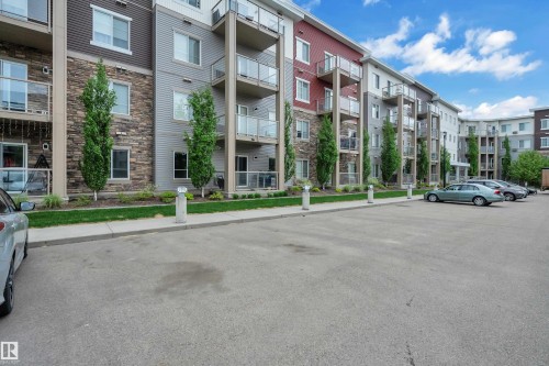 Multi-story building exterior featuring varied siding, stone accents, and private balconies with glass railings - 115 812 Welsh Drive Sw, Edmonton, AB 