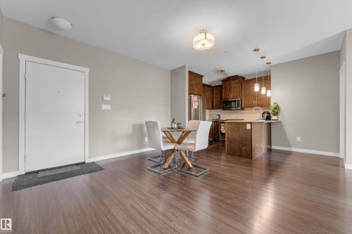 Open-concept living space with wood-finish flooring - 115 812 Welsh Drive Sw, Edmonton, AB 