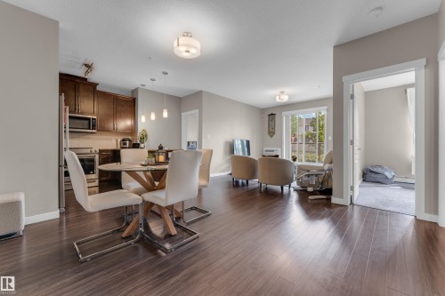 Open-concept living space featuring wood-finish flooring throughout - 115 812 Welsh Drive Sw, Edmonton, AB 