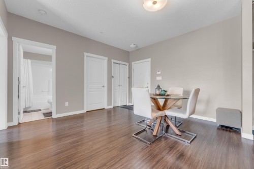 Spacious interior featuring wood-finish flooring, neutral paint tones, and white trim throughout - 115 812 Welsh Drive Sw, Edmonton, AB 
