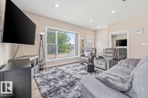 Spacious living area featuring light-toned walls, recessed lighting, and wood-finish flooring - 4708 47A Avenue, Onoway, AB 