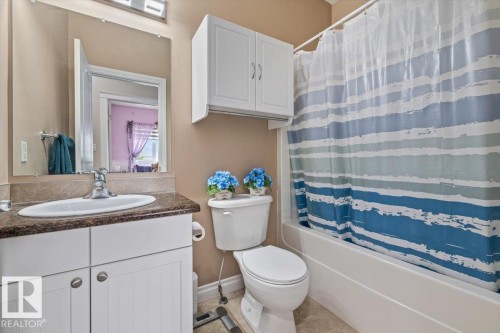 Bathroom featuring a white vanity with a dark countertop, a built-in sink, and a chrome faucet - 4708 47A Avenue, Onoway, AB 