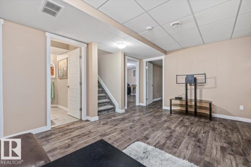 Room featuring wood-finish flooring, neutral wall paint, and white trim - 4708 47A Avenue, Onoway, AB 