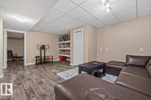 Spacious entertainment room featuring wood-finish flooring, recessed lighting, and a drop ceiling - 4708 47A Avenue, Onoway, AB 