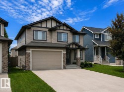 Modern two-story residence featuring a neutral-toned siding exterior with dark trim accents - 