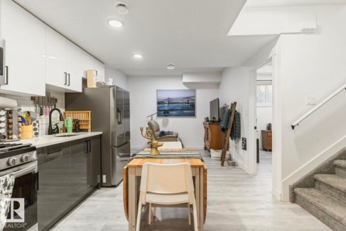Contemporary kitchen featuring two-tone cabinetry, stainless steel appliances, and light countertops - 19703 29 Avenue, Edmonton, AB 