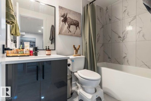 Bathroom featuring a modern vanity with dark gray cabinetry, white countertop, and rectangular sink - 19703 29 Avenue, Edmonton, AB 