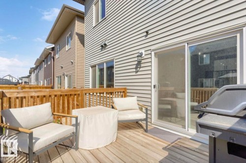 Private wooden deck featuring a sliding glass door and durable siding - 19703 29 Avenue, Edmonton, AB 