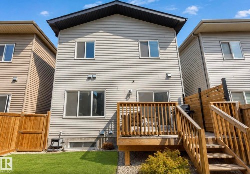 Rear exterior featuring a multi-level wood deck, privacy fencing, and a manicured lawn - 19703 29 Avenue, Edmonton, AB 
