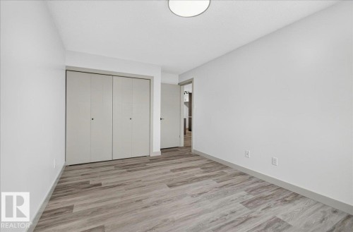 Room featuring light wood-finish flooring, white walls, and a contemporary ceiling light fixture - Edmonton, AB 