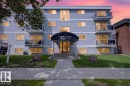 Multi-story residential building featuring light-colored siding and multiple balconies with glass railings - Edmonton, AB 