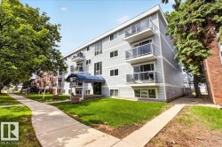Multi-story building featuring gray horizontal siding and individual balconies with glass railings - 