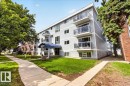 Multi-story building featuring gray horizontal siding and individual balconies with glass railings - Edmonton, AB 
