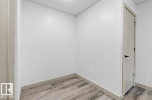 Neutral wall finishes with a modern door featuring a matte black handle - Edmonton, AB 