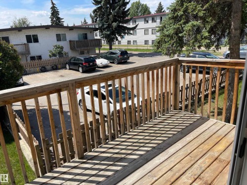 Wood-finish balcony with slatted railing and direct access to an outdoor parking area - 8930B 144 Avenue, Edmonton, AB 
