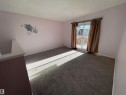 Carpeted interior space featuring a sliding glass door with access to an exterior deck - 8930B 144 Avenue, Edmonton, AB 