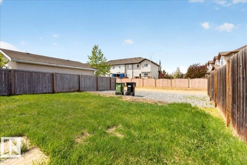 Expansive backyard featuring a large grass area and a perimeter wooden fence - 150 Acacia Circle, Leduc, AB - Outdoor