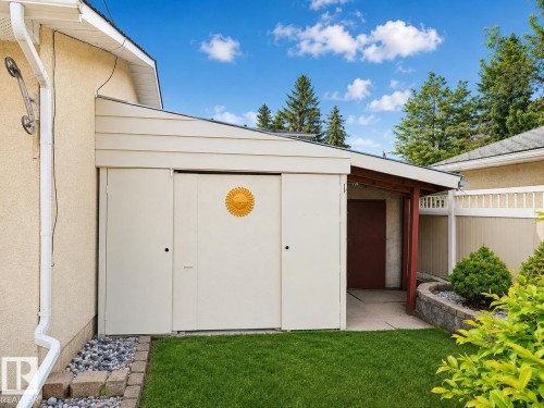 Detached storage structure featuring sliding panel doors, a lean-to roof, and an adjacent covered walkway - 7612 40 Avenue Nw, Edmonton, AB - Outdoor With Exterior