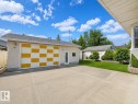 Detached garage featuring a checkerboard pattern door, a pedestrian entry door, and exterior lighting - 7612 40 Avenue Nw, Edmonton, AB  - Outdoor 