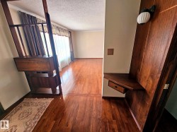 Rich wood-finish flooring throughout, complemented by a built-in wood-finish partition with integrated shelving and a drawer - 