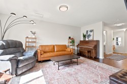 Spacious living area featuring wood-finish flooring, recessed lighting, and a neutral color palette - 