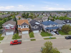 Residential neighborhood featuring a variety of detached homes with attached garages, paved driveways, and mature landscaping - 