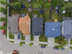 Residential streetscape featuring a curved road with sidewalks and multiple detached homes - 