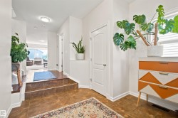 Foyer featuring large format floor tiling, white baseboards, and a solid interior door with a brushed nickel knob - 