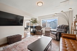 Open concept living area featuring a neutral color palette, ceiling-mounted light fixture, large window, and wood-finish flooring - 