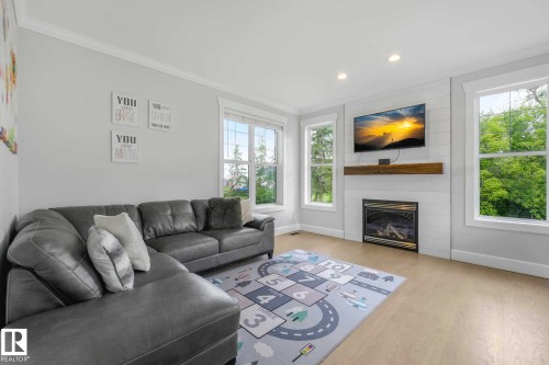 Living area featuring light wood-finish flooring, recessed lighting, natural gas fireplace, and white trim - 553006 Range Road 153, Rural Two Hills County, AB - Indoor Photo Showing Living Room With Fireplace