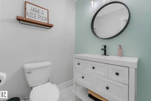 Bathroom featuring a white vanity with integrated sink, matte black faucet, and oval-framed mirror - 553006 Range Road 153, Rural Two Hills County, AB - Indoor Photo Showing Bathroom