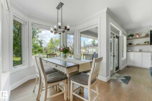 Dining area featuring a bay window, wood-finish flooring, and a contemporary chandelier - 553006 Range Road 153, Rural Two Hills County, AB - Indoor Photo Showing Dining Room