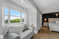 Bedroom featuring light wood-finish flooring, a distinct accent wall, and recessed lighting - 