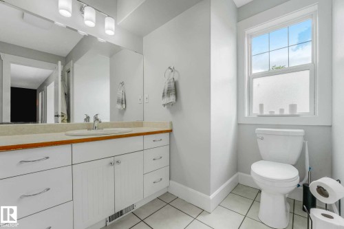 Bathroom featuring a white vanity with wood-finish trim, a single basin sink, and a large mirror - 553006 Range Road 153, Rural Two Hills County, AB - Indoor Photo Showing Bathroom