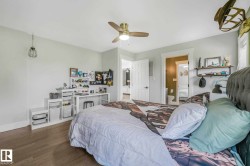 Light-filled interior space featuring wood-finish flooring, a ceiling fan with integrated lighting, and an open doorway leading to an additional space - 