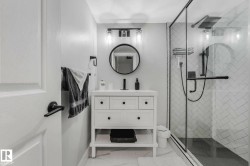 Bathroom featuring a glass-enclosed shower with subway tile in a herringbone pattern - 