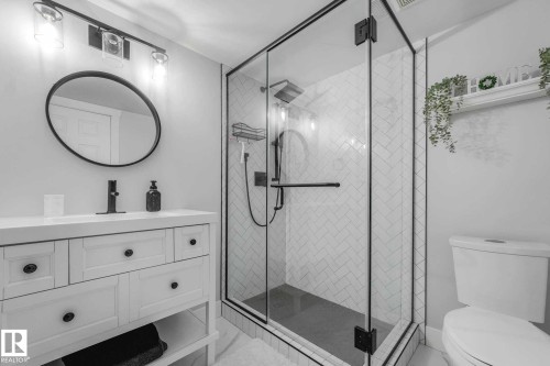Glass-enclosed shower with black trim and herringbone tile surround - 553006 Range Road 153, Rural Two Hills County, AB - Indoor Photo Showing Bathroom