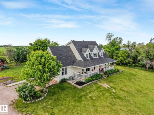 Charming two-story home featuring a broad covered front porch with white railings - 553006 Range Road 153, Rural Two Hills County, AB - Outdoor With Deck Patio Veranda