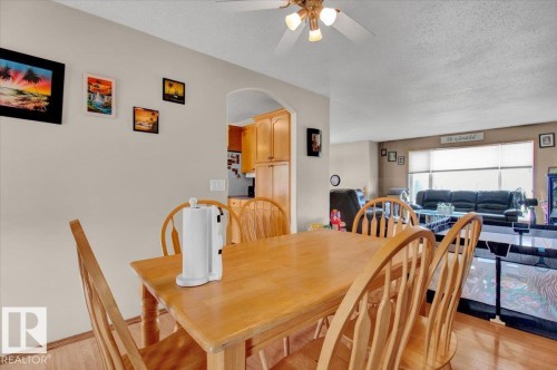 Open concept dining area with wood-finish flooring, an arched entryway, and a ceiling fan with integrated lighting - 5506 53St, Mundare, AB 