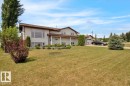 Traditional-style home featuring light-colored siding, a brown roof, and a covered front porch with white pillars - 5506 53St, Mundare, AB 
